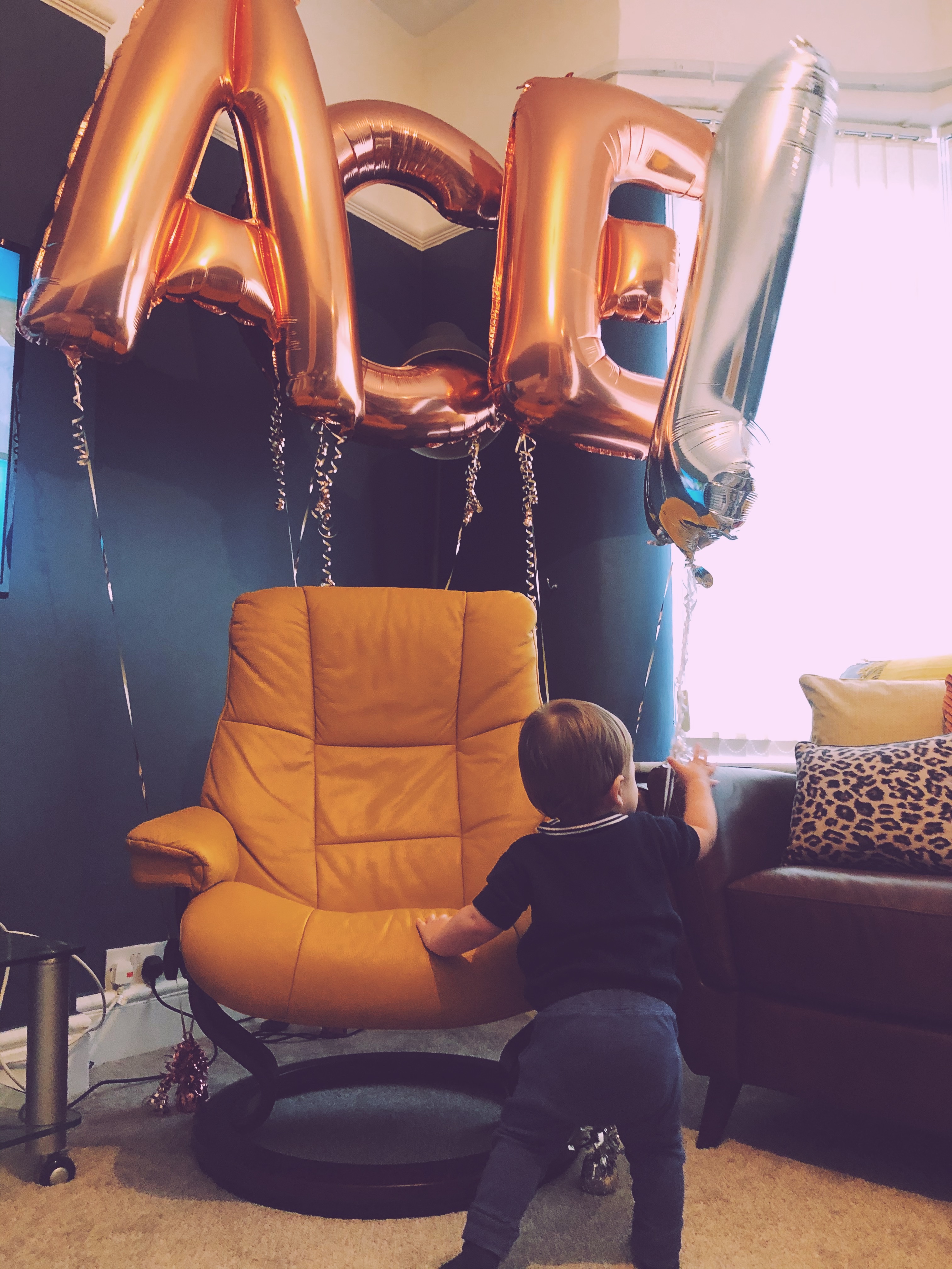 Baby boy with birthday balloons