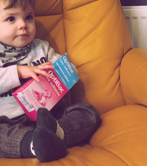 baby holding a box of probiotics